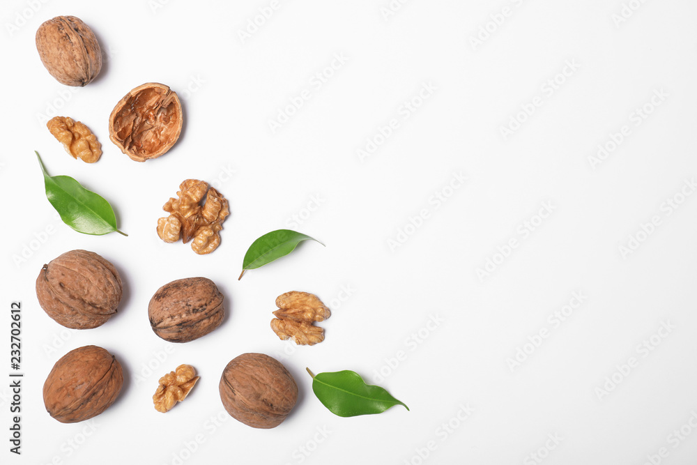 Walnuts with leaves on white background, flat lay with space for text Walnuts with leaves on white background, flat lay with space for text