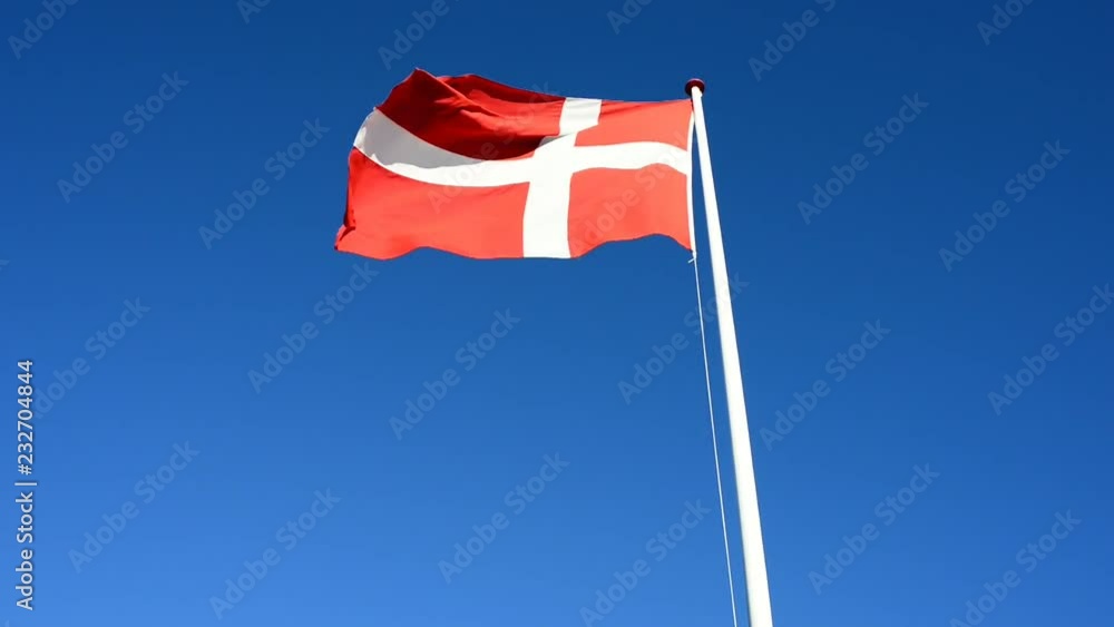 The wind blows the Danish national flag in the wind on clear sky The wind blows the Danish national flag in the wind on clear sky