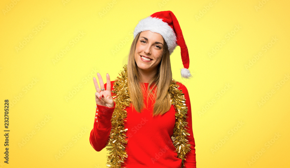 Blonde woman dressed up for christmas holidays happy and counting three with fingers on yellow background Blonde woman dressed up for christmas holidays happy and counting three with fingers on yellow background