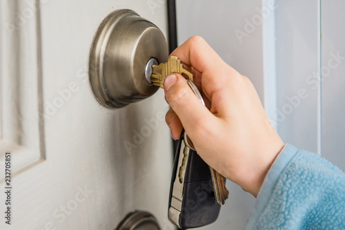 Hand turns the key in the door lock