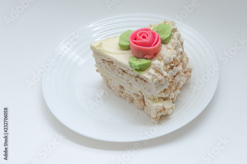piece of meringue cake decorated with a rose on a plate