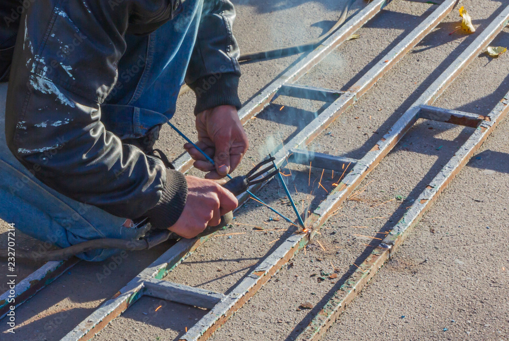 welder working on the street making a hedge welder working on the street making a hedge
