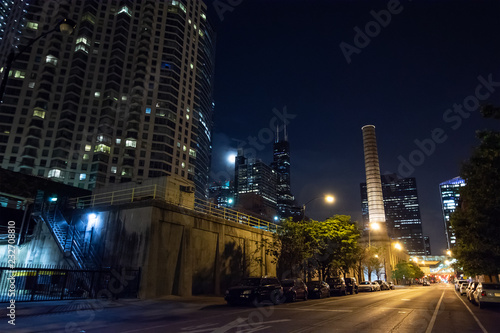 Chicago night street scene with a city tower  a smokestack  the 