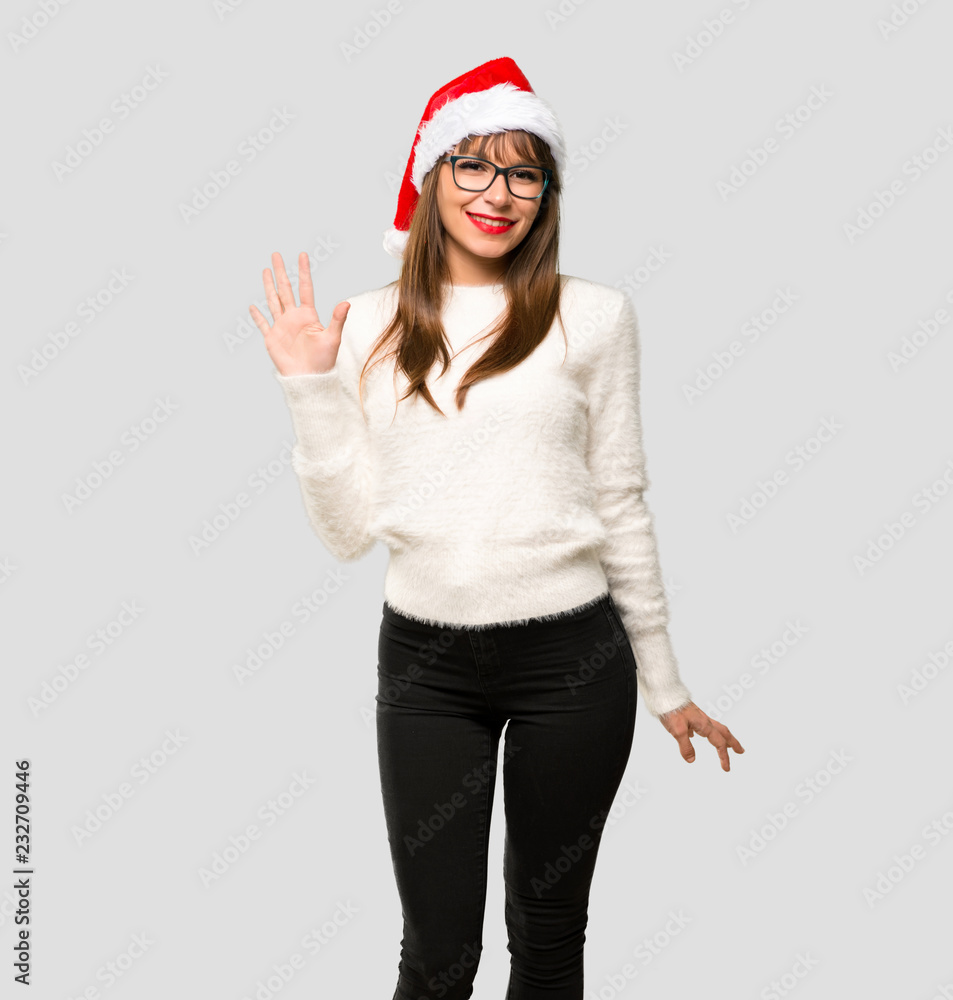 Girl with celebrating the christmas holidays counting five with fingers on isolated grey background Girl with celebrating the christmas holidays counting five with fingers on isolated grey background