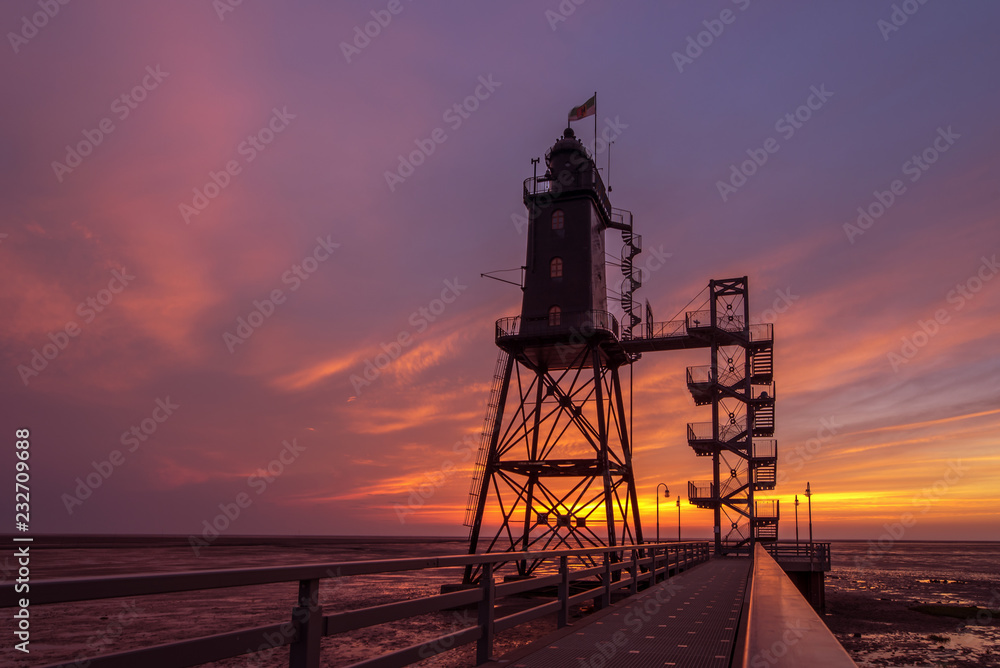 The former lighthouse Eversand-Oberfeuer built in 1886/87 is now a museum and a tourist attraction. Here during the sunset. Concept: travel and vacation