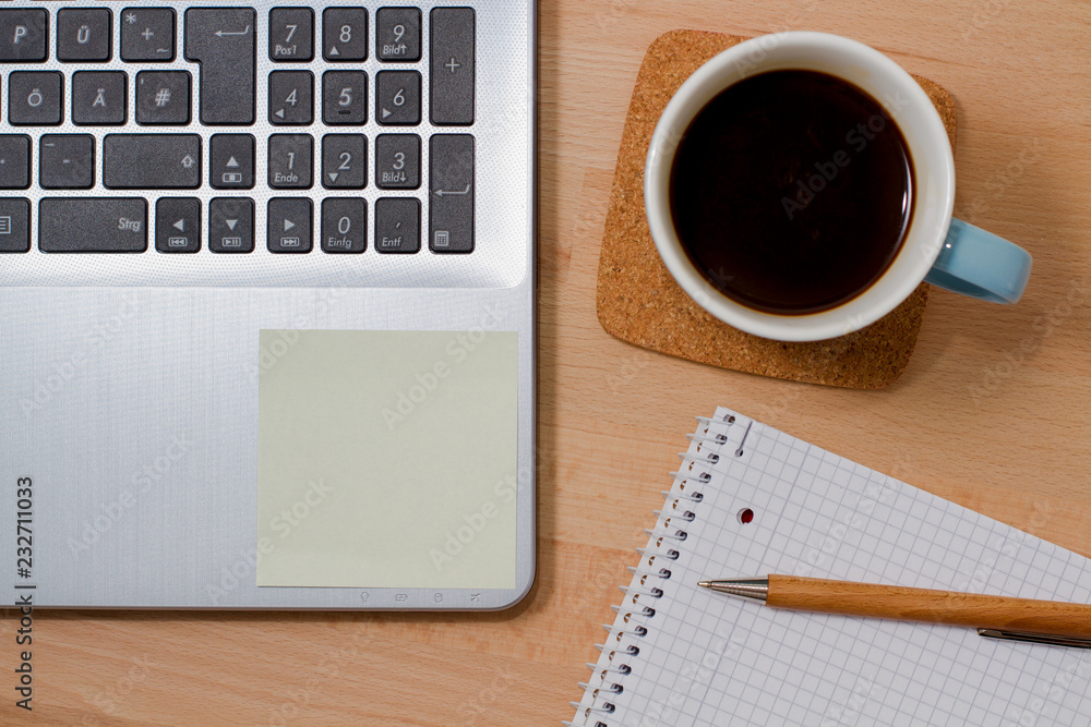 Post-it on laptop with coffee and spiral block on the side Post-it on laptop with coffee and spiral block on the side