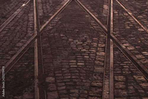 Crossing of tram rails on stone pavement in the city abstract background