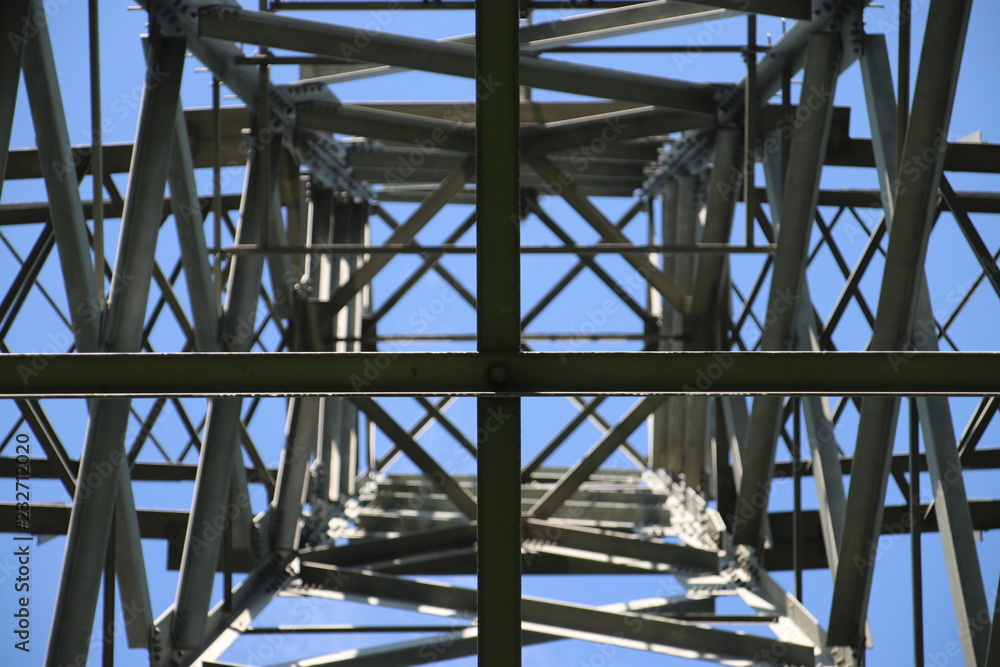 Power lines on a tower with blue sky and cirrus clouds in Rotterdam Nesselande as a symmetric view Power lines on a tower with blue sky and cirrus clouds in Rotterdam Nesselande as a symmetric view