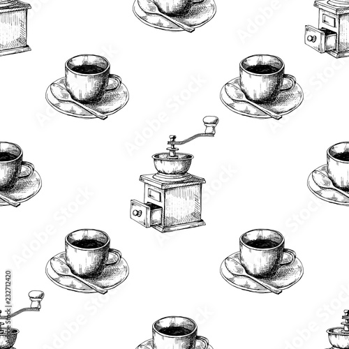 Retro manual coffee grinder or mill and mug of coffee on a saucer.