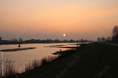 sunrise above the river Hollandsche IJssel at the village Nieuwerkerk in the Netherlands.