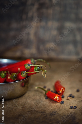 Bitter red pepper in a rustic style on a wooden board. Dark background and red hot pepper.