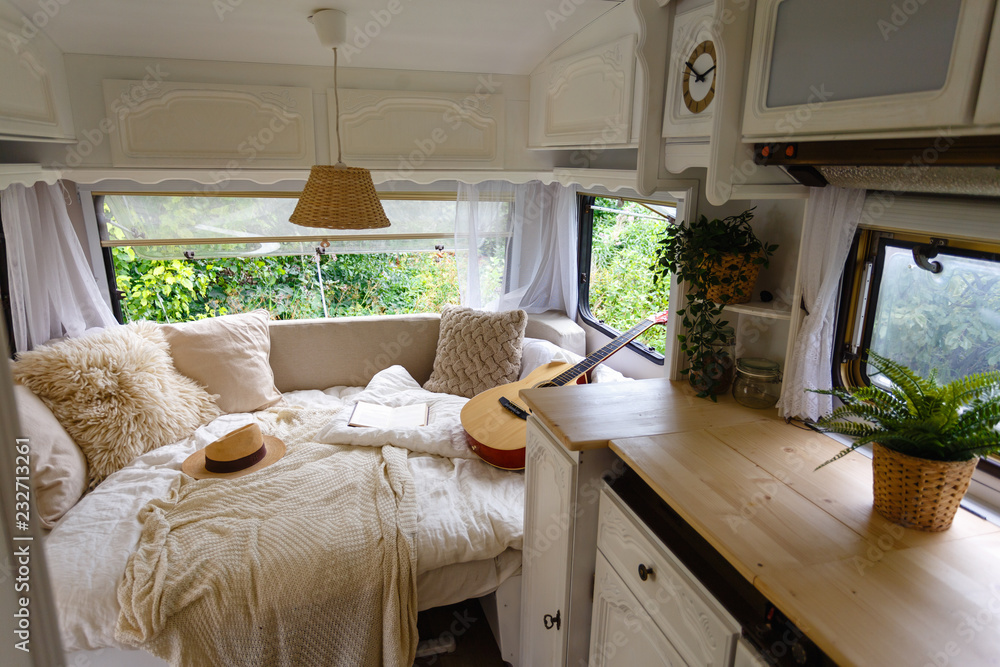Sierkussen In de camper. Ongevuld bed, kussens, gitaar, boek, hoed, witte  houten decoratie van het huis op wielen. - Nikkel-Art.nl