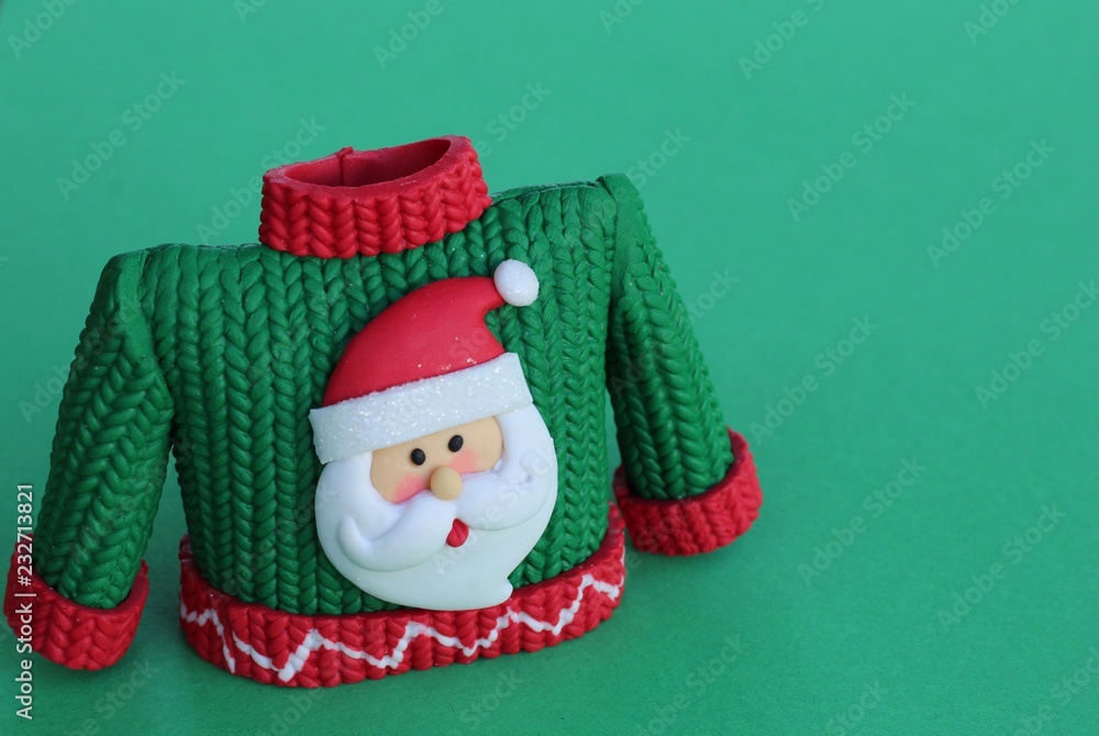 green and red resin sweater with Santa Claus wearing hat and beard standing on a green background with writing space green and red resin sweater with Santa Claus wearing hat and beard standing on a green background with writing space