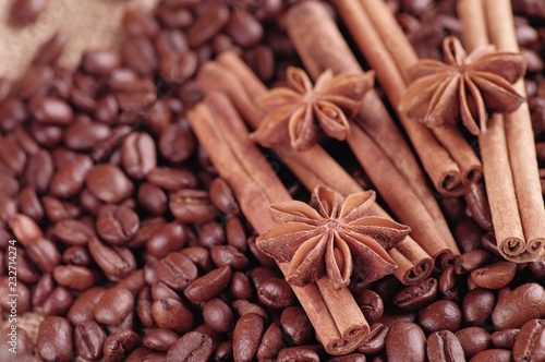 Aromatic roasted coffee beans and anis or badian, sticks of natural cinnamon on background close up