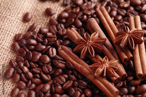 Aromatic roasted coffee beans and anis or badian, sticks of natural cinnamon on background close up