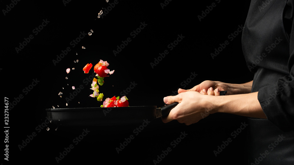 Chef preparing vegetables on a dark background on a grill pan