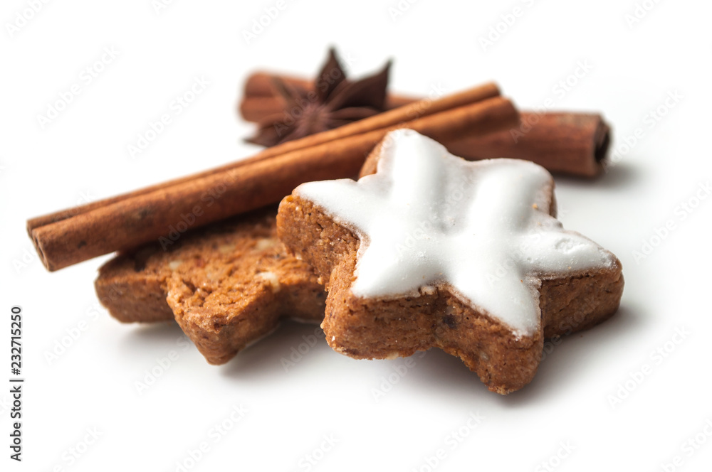closeup of christmas biscuit shaped star with anise flower and cinnamon stick on white background closeup of christmas biscuit shaped star with anise flower and cinnamon stick on white background