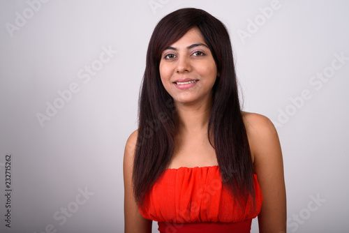 Close up of young happy Persian woman smiling while wearing red  © Ranta Images