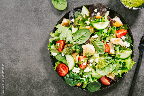 Tasty fresh salad with chicken, pesto and vegetables