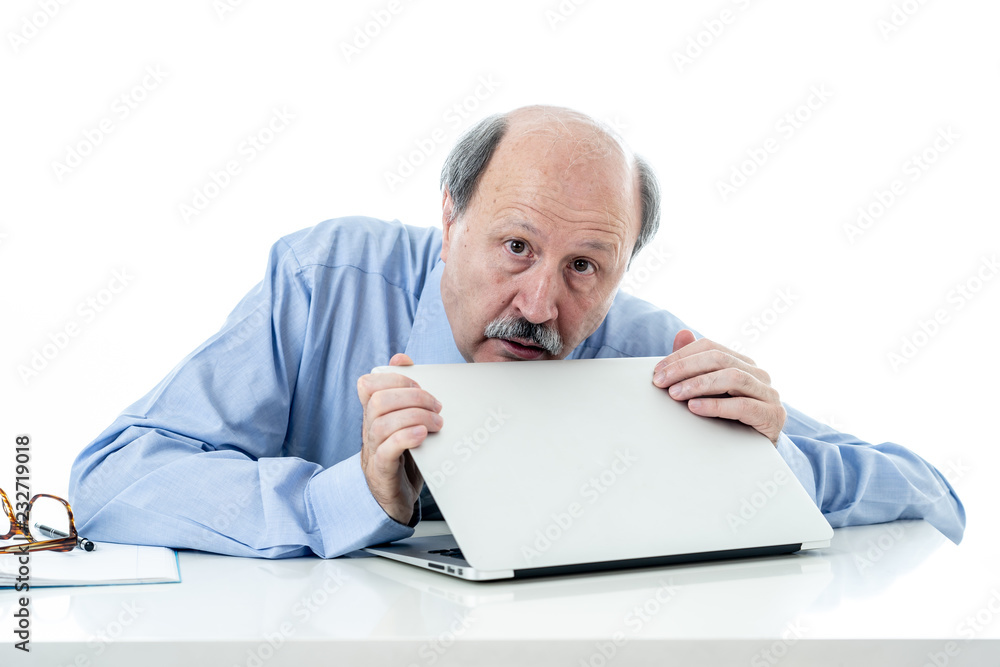 Overwhelmed and tired old businessman working with laptop feeling angry at office Overwhelmed and tired old businessman working with laptop feeling angry at office