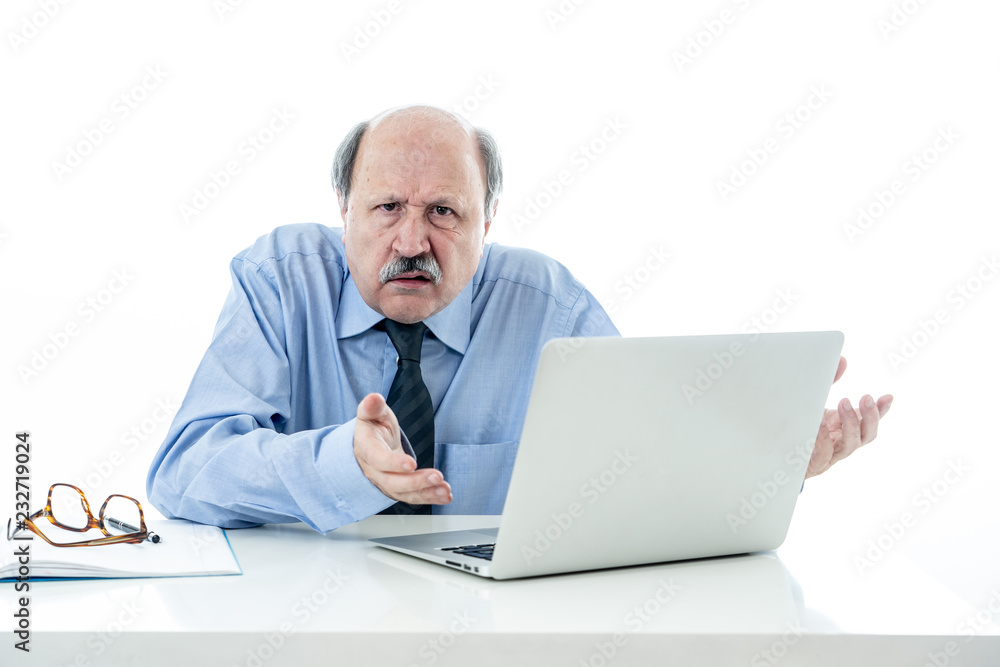 Overwhelmed and tired old businessman working with laptop feeling angry at office Overwhelmed and tired old businessman working with laptop feeling angry at office