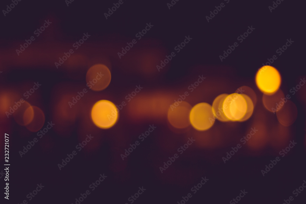 Blurry distant city lights at night. Calm yellow blurry traffic lights in the distance
