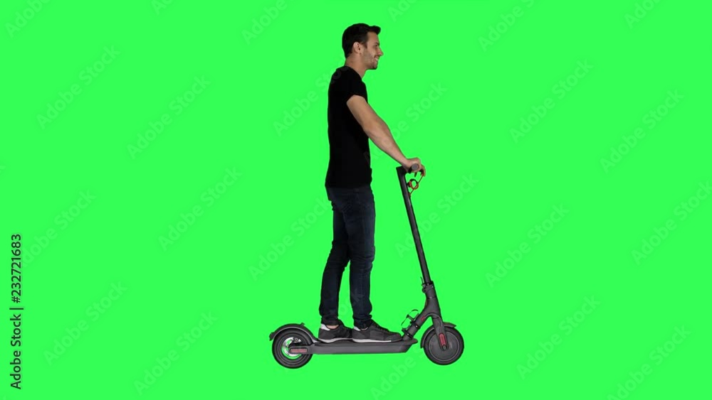 Riding an electric scooter by a casual looking young man. turns left and right over a green screen, Riding an electric scooter by a casual looking young man. turns left and right over a green screen,