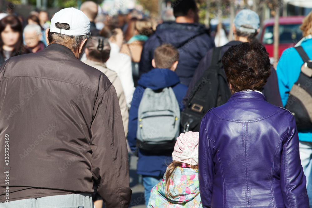 Obraz premium Crowd of people walking on street sidewalk. View from the back. Concept of street and crowd.
