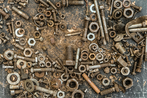 Old worn metal bolts and screw-nuts in set. Spent fasteners close-up.