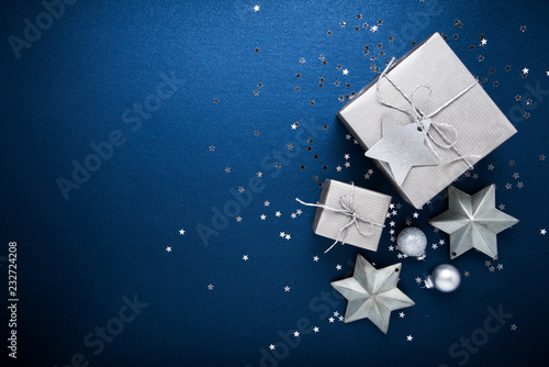 Christmas and New Year holiday background. Xmas greeting card. Christmas silver gifts on blue background top view. Flat lay