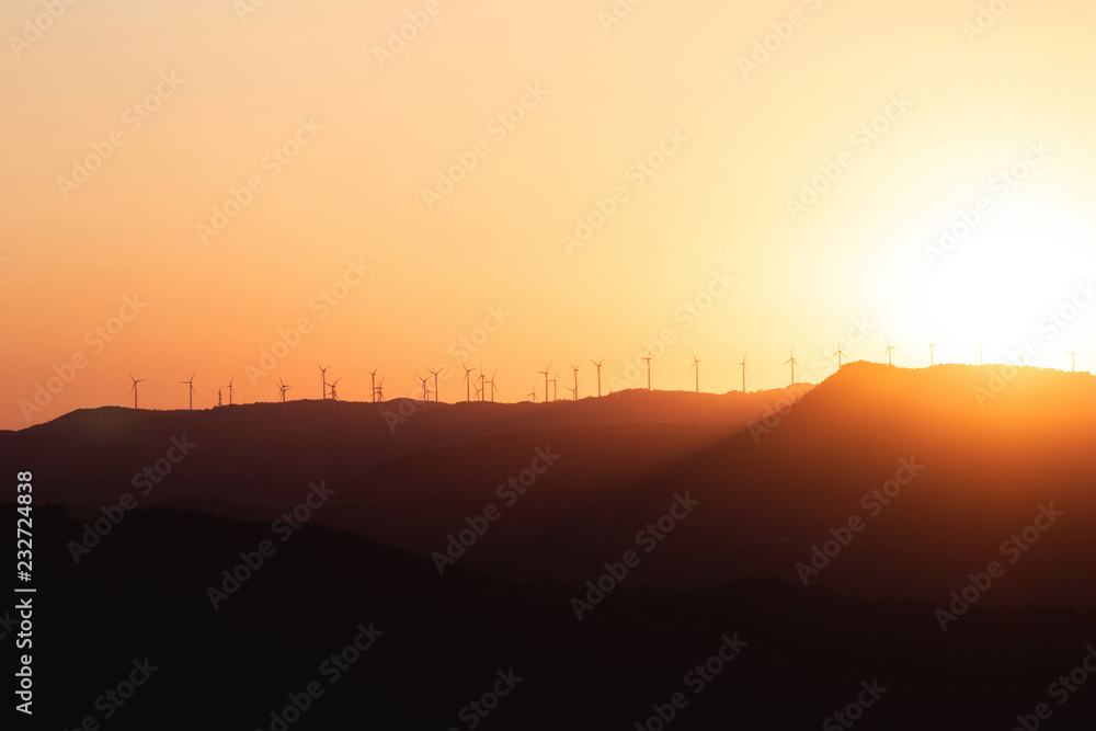 Late bright sunset with windmills on the horizon