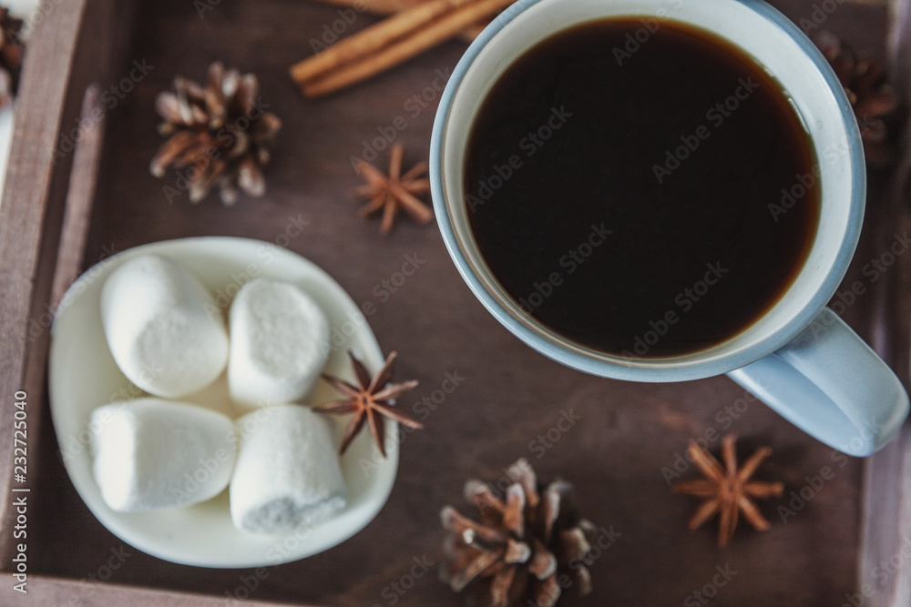Cup of coffee on rustic wooden tray, sweet marshmallow and warm woolen sweater. Cozy autumn or winter weekend or holidays at home. Fall home decoration with hot drink mug. Hygge morning style concept Cup of coffee on rustic wooden tray, sweet marshmallow and warm woolen sweater. Cozy autumn or winter weekend or holidays at home. Fall home decoration with hot drink mug. Hygge morning style concept