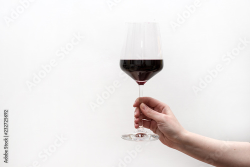 hand with glass of red wine