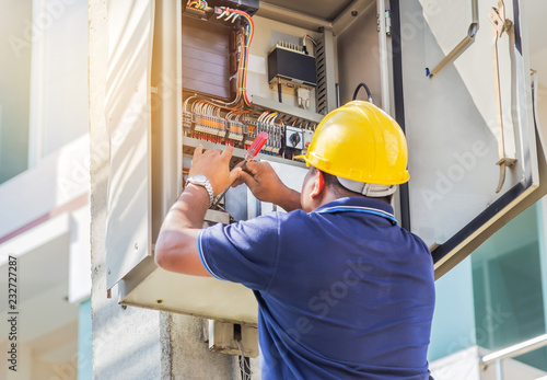 Electrician screwing equipment repairing in fuse circuit breaker box