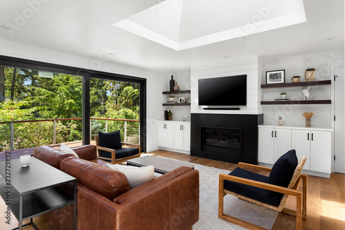 Foto Beautiful living room in new home with exterior view of trees, fireplace, and tv