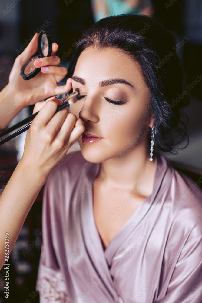 A beautiful bride makeup artist applies makeup. Wedding morning of the bride A beautiful bride makeup artist applies makeup. Wedding morning of the bride