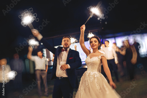 The bride and groom waving Bengal lights