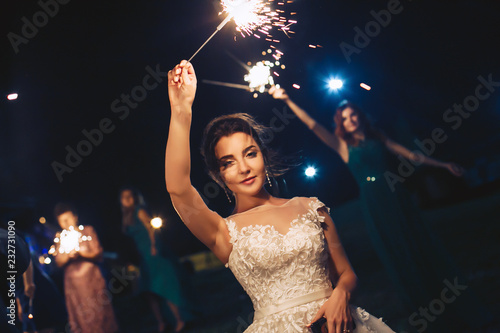 Bride during the evening wedding ceremony waving sparkler