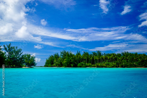 View of clear, vibrant turquoise waters and green forest of Moorea island and its famous lagoon in French Polynesia, in the south Pacific Ocean