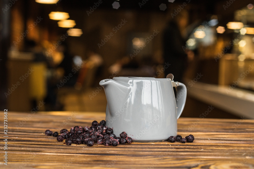 Hot tea with berries, wood background, teapot with tea, cosiness Hot tea with berries, wood background, teapot with tea, cosiness