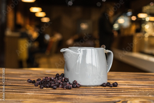 Hot tea with berries, wood background, teapot with tea, cosiness