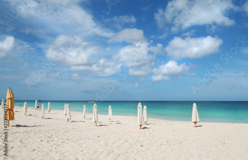 Fototapeta Naklejka Na Ścianę i Meble -  Oranjestad, Aruba. Unrecognizable People Walking Along White Sands at Eagle Beach. Dramatic Clouds