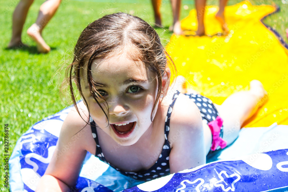 Gratificante plato Moral Feliz niña jugando con agua en traje de baño Stock Photo | Adobe Stock