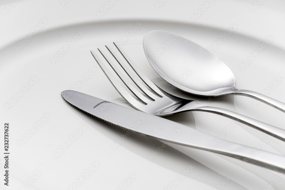 Fork and spoon on an empty plate