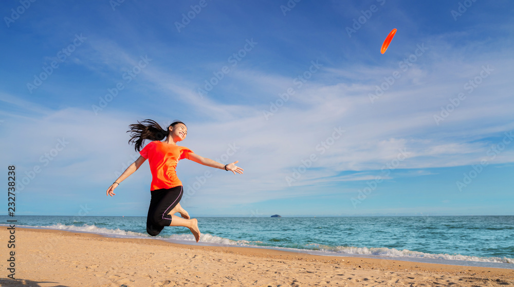 Asian girl play flying disc on the beach Asian girl play flying disc on the beach