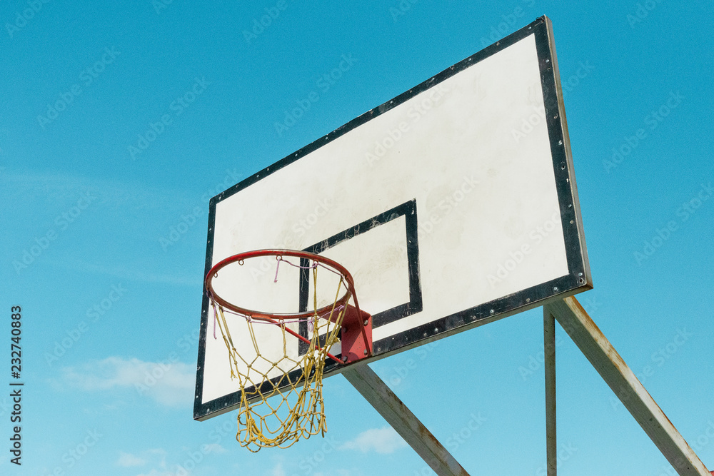 White basketball shield on the playground on background of blue sky