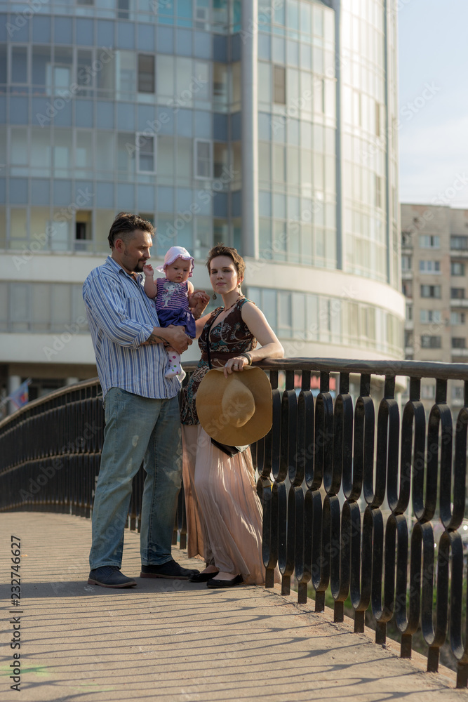 portrait of a couple with a baby on the bridge