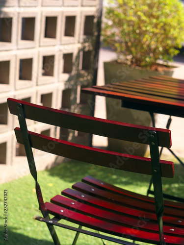 Wooden dining table and chair at green yard balcony in morning.