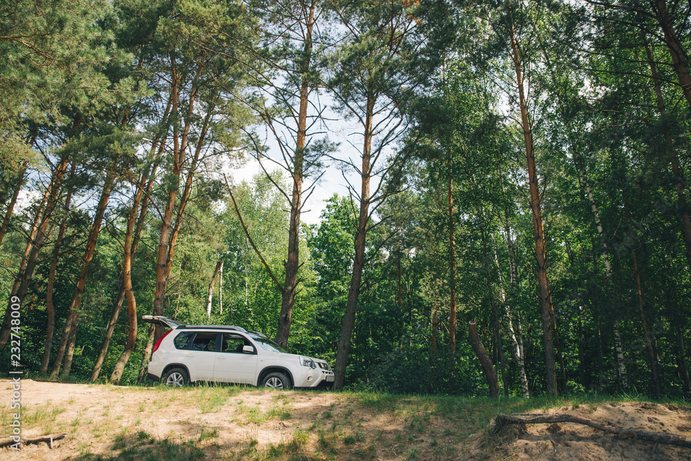 white suv in forest. car travel concept. lifestyle white suv in forest. car travel concept. lifestyle