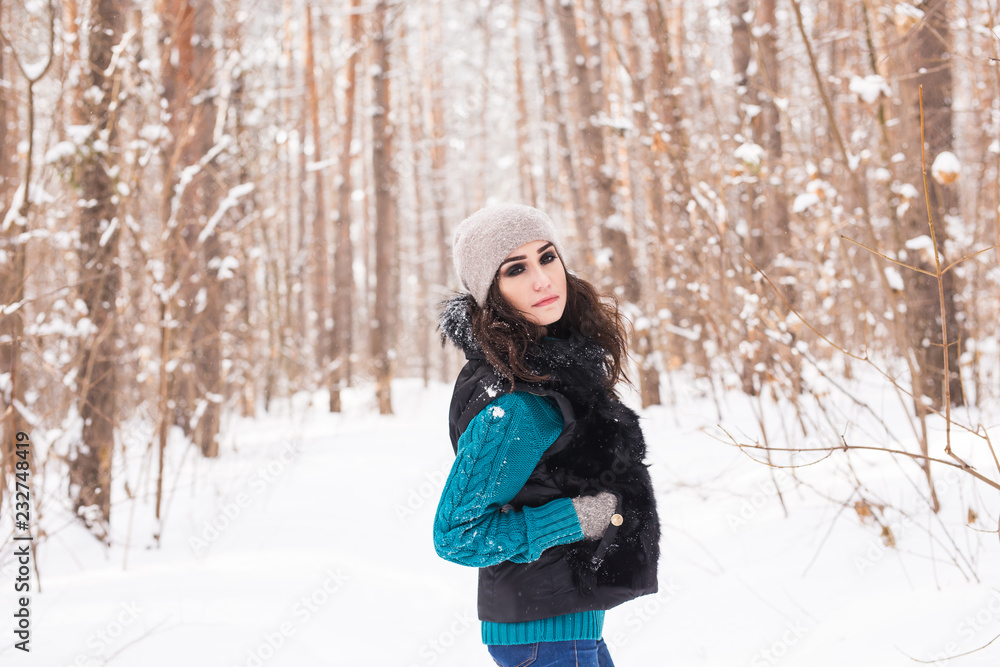 Happy young woman walking in winter time. Pretty girl in snowy nature Happy young woman walking in winter time. Pretty girl in snowy nature